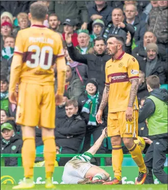  ??  ?? Kieran Tierney is left in agony after an over the top tackle from Motherwell’s Ryan Bowman