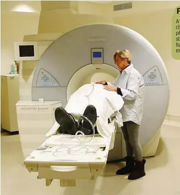  ??  ?? Maureen Bryant comforts her husband, Stu, as he lays on the table of an MRI machine for a study of frontotemp­oral dementia.