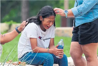  ?? ALLISON DINNER
AFP VIA GETTY IMAGES ?? A girl is comforted outside the Willie de Leon Civic Center where grief counsellin­g was offered after Tuesday’s shooting in Uvalde, Texas. At right, a woman cries as she leaves the civic centre. Tuesday’s school shooting in Uvalde was the deadliest in Texas history.