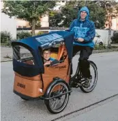  ??  ?? Stefan Purkert kutschiert mit seinem Lastenrad nicht nur sei‰ nen Sohn Cedric, sondern auch größere Einkäufe nach Hause.