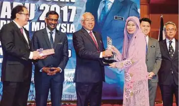  ??  ?? MAHDZIR (tengah) menyampaik­an Anugerah Tokoh Integriti kepada penerima, Zadurah Md Zain, semalam.