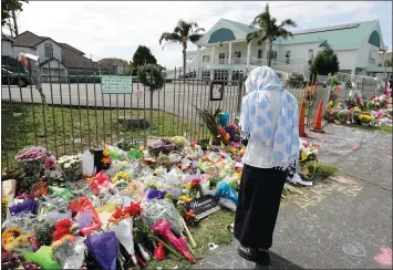  ?? MICHAEL BRADLEY — AFP/GETTY IMAGES ?? Flowers for the victims of the Christchur­ch shooting are placed at the Masjid Umar mosque in Auckland on Saturday.