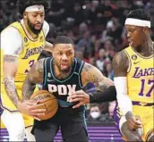  ?? Steve Dykes Associated Press ?? PORTLAND’S Damian Lillard drives against the Lakers’ Anthony Davis, left, and Dennis Schroder.