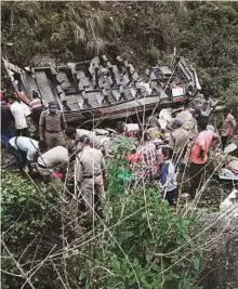  ?? PTI ?? Rescuers retrieve bodies after a bus fell into a deep gorge, in Pauri yesterday. At least 48 people were killed and 10 others injured.