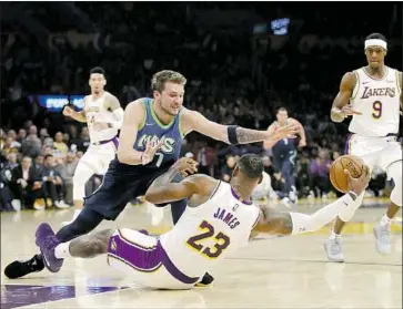  ?? Marcio Jose Sanchez Associated Press ?? LeBRON JAMES and the Lakers fell on their rear ends against Luka Doncic and the Mavericks, who shot 49 threes to beat them and got a near triple-double from Doncic with 27 points, 10 assists and nine rebounds.