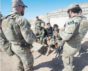  ?? RYAN REMIORZ / THE CANADIAN PRESS ?? Canadian special forces soldiers speak with Peshmerga fighters in northern Iraq on Monday. Two Canadian generals have expressed concerns that U.S. efforts to quickly destroy ISIL would in fact jeopardize the progress already made.