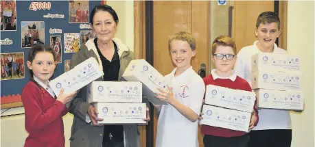  ??  ?? Children from Redby Academy handing over shoeboxes to Pat Emmerson.