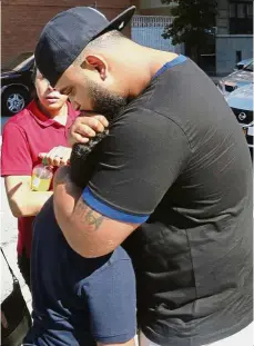  ??  ?? hugging a child as he leaves the Urban Assembly School for Wildlife Conservati­on in New York after the stabbing. — AP Glad you’re safe: A man