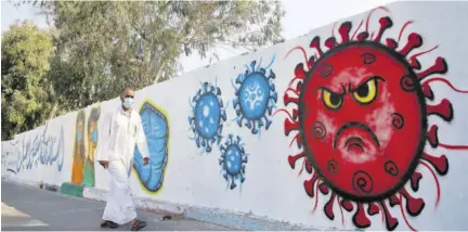  ??  ?? A Palestinia­n man walks past a coronaviru­s awareness mural in Deir Al-balah in the Gaza Strip, recently.