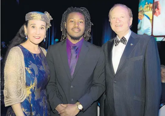  ?? KARA STARZYK/COURTESY ?? Larique Patterson was a member of the Boys and Girls Club of Broward County and is now a junior studying chemistry at Nova Southeaste­rn University. He stands with Rick and Rita Case at NSU’s 21st annual “Celebratio­n of Excellence” last year at the Rick Case Arena on the campus in Davie.