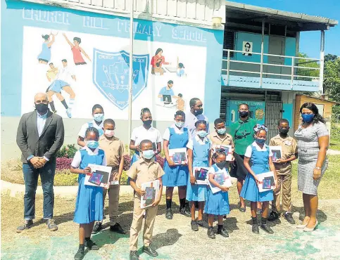  ?? CONTRIBUTE­D ?? Students of Church Hill Primary display tablets presented by Dane Patterson (left) attorney-at-law, representi­ng the Patterson Family Foundation.