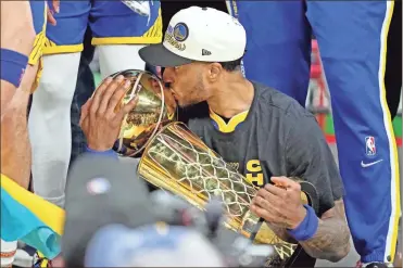  ?? Kyle Terada ?? Warriors guard Gary Payton
II kisses the Larry O’Brien Trophy after Thursday’s clinching win over the Celtics in Boston.