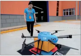  ?? XINHUA ?? An employee of Cainiao Network, the logistics arm of Alibaba, receives a delivery from a drone at a storage facility in Xi’an, capital of Shaanxi province.