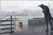  ?? AFP ?? A man is splashed by the swell from Victoria Harbour during heavy winds and rain brought on by Typhoon Hato in Hong Kong.