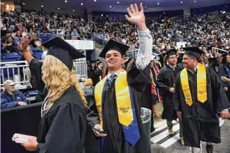  ?? Arnold Gold/Hearst Connecticu­t Media ?? Edward Smith waves to family as the Southern Connecticu­t State University undergradu­ate commenceme­nt begins at the Total Mortgage Arena in Bridgeport Friday.
