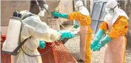  ?? PHOTOGRAPH COURTESY OF UN ?? AN IFRC worker sprays disinfecti­ng chlorine solution on the gloved hands of a fellow worker in Conakry, Guinea.