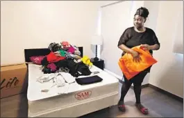  ??  ?? NIECY begins to unpack clothing the day she moved into her new unit. “Oh, this is big. Oh, my goodness!” she said. “I thought this was never going to happen.”