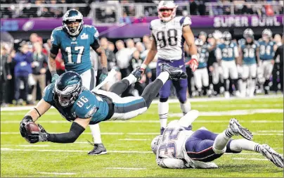  ?? AP PHOTO ?? Philadelph­ia Eagles tight end Zach Ertz dives into the end zone over New England Patriots free safety Devin McCourty for a touchdown during the fourth quarter of Super Bowl 52.