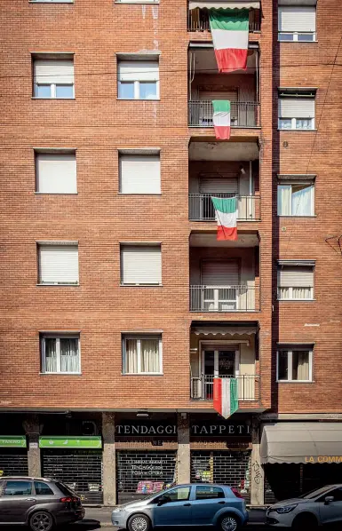  ?? (Passaro) ?? Tricolori Le bandiere italiane appese alle finestre di un palazzo: simbolo di resistenza al virus Covid-19