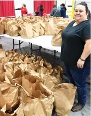  ?? The Sentinel-Record/Tanner Newton ?? ■ Toni Gipson, coordinato­r for Stomp Out Hunger, stands inside Arkansas Beverage Sales Inc. with 200 bags of food that were donated to The Salvation Army’s annual Angel Tree giveaway.