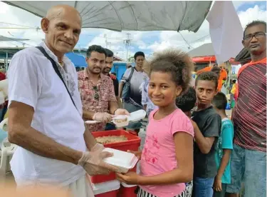  ??  ?? Arun Padarath (second from left), with his team distributi­ng food packs at the Suva Bus Stand over the weekend.