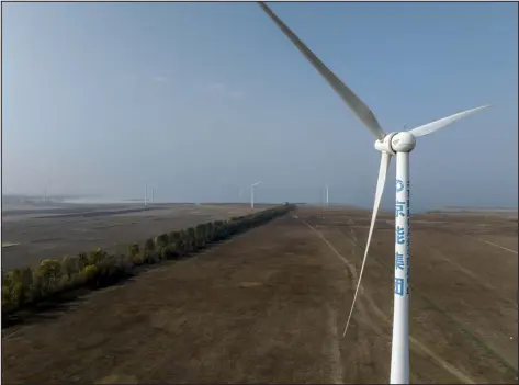  ?? GILLES SABRI — THE NEW YORK TIMES ?? Wind turbines in marshlands north of Beijing on Oct. 25. Chinese turbine manufactur­ers, having honed their production at home, are expanding to overseas markets.