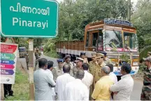  ?? — ASIAN AGE ?? Police guard the entrance to Pinarayi village following a political killing in the area.
