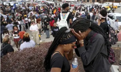  ?? Photograph: David Carson/AP ?? Students in a parking lot near the Central Visual & Performing Arts high school after a shooting at the school in St Louis.