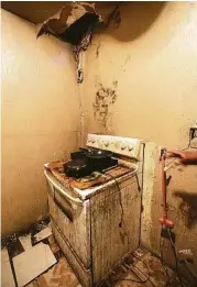  ?? Elizabeth Conley / Houston Chronicle ?? Spot Williams uses hot pads for cooking atop a stove damaged by flooding during Hurricane Ike in 2008. The kitchen also no longer has running water.