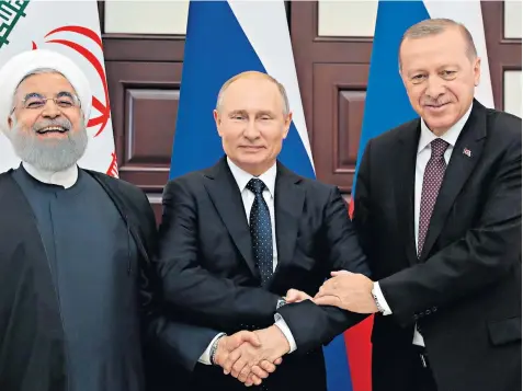  ??  ?? Vladimir Putin, Russia’s president, greets Recep Tayyip Erdogan, president of Turkey, right, and Hassan Rouhani, left, the president of Iran, at a trilateral meeting on Syria in Sochi