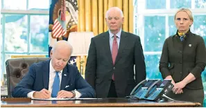  ?? AP Photo/Manuel Balce Ceneta ?? President Joe Biden signs the Ukraine Democracy Defense Lend-Lease Act of 2022 in the Oval Office of the White House Monday. Witnessing the signing are Ukraine-born Rep. Victoria Spartz, R-Ind., right, and Sen. Ben Cardin, D-Md.