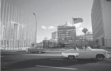  ?? RAMON ESPINOSA, AP ?? Tourists ride in classic American convertibl­es past the U. S. Embassy, right, in Havana.