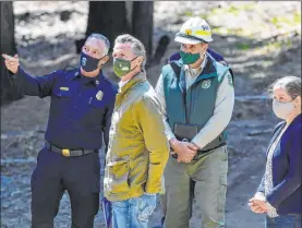  ?? Craig Kohlruss The Associated Press ?? Gov. Gavin Newsom meets with fire officials Thursday while touring an area burned by last year’s Creek Fire near Shaver Lake in Fresno County, Calif.