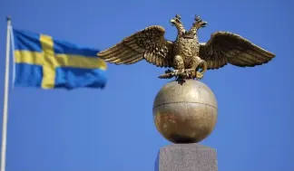  ?? ?? A Russian Imperial double-headed eagle is seen in front of a Sweden flag on the Czarina's Stone in the Market Square, in Helsinki, Finland, Friday, May 13, 2022