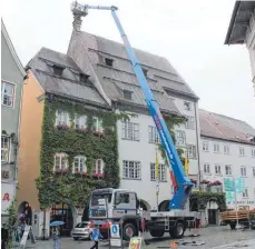  ?? FOTO: SCHUMACHER ?? Die angemietet­e Spezial-Hebebühne am Dienstag vor dem Rathaus, oben im Korb arbeiten Ute Reinhard und Ulrike Maruszczak.