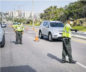  ?? FOTOS ORLANDO AMADOR ?? Varios policías de tránsito realizan un control vehicular en la vía a Cartagena.
