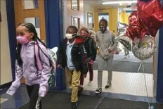  ?? Pittsburgh Post-Gazette ?? Wilkins Elementary STEAM Academy students arrive at school Monday after the Woodland Hills School District resumed in-person learning.