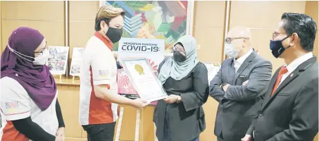  ?? — Bernama photo ?? Dr Roziah (third right) receives a certificat­e from Malaysia Book of Records marketing director Jwan Heah.