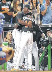  ??  ?? Miami Marlins hitting coach Barry Bonds, left, hugs Dee Gordon, right, after he hit a solo home run during the first inning in a baseball game against the New York Mets.