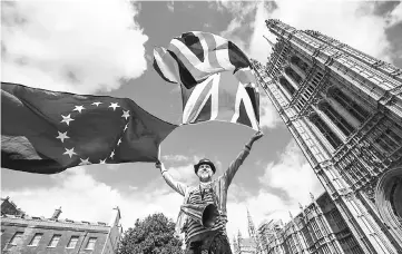  ??  ?? Pro-European Union demonstrat­ors protest outside the Houses of Parliament in central London against the first vote on a bill to end Britain’s membership of the EU. Deepening uncertaint­ies over the direction and timetable of Brexit negotiatio­ns may...