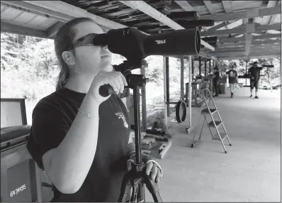  ?? NWA Democrat-Gazette/FLIP PUTTHOFF ?? Annie Downum, a member of the Ozark Youth Shooting Team, checks her targets Saturday during a team practice near Bentonvill­e. Team members will compete in the Daisy National BB Gun Championsh­ip Match in Rogers this weekend.