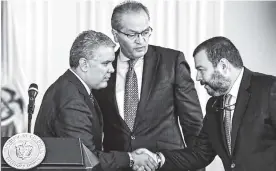  ?? AFP ?? El presidente Ivan Duque y el defensor del pueblo Carlos Alfonso Negret junto al procurador general Fernando Carrillo durante la firma del decreto.