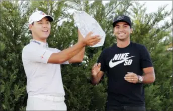  ?? LYNNE SLADKY — THE ASSOCIATED PRESS ?? Si Woo Kim holds The Players Championsh­ip Trophy Sunday in Ponte Vedra Beach, Fla. To the right is Jason Day, who won the tournament last year.