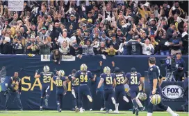  ?? BUTCH DILL/ASSOCIATED PRESS ?? Saints players rush toward fans after New Orleans sacked Carolina quarterbac­k Cam Newton, forcing the Panthers to turn the ball over on downs. New Orleans will visit Minnesota in the next round of the playoffs.