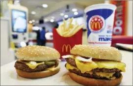  ?? MIKE STEWART — THE ASSOCIATED PRESS ?? A McDonald’s Quarter Pounder, left, and Double Quarter Pound burger are shown with fresh beef Tuesday in Atlanta.