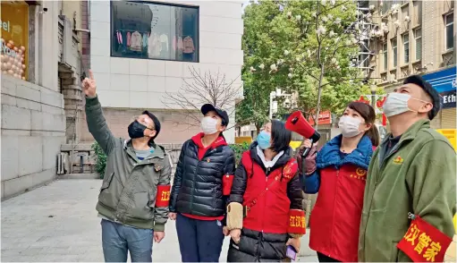  ??  ?? On March 11, government officials and local volunteers are carrying out the control and inspection work on the epidemic in the Jiaotong Community, Shuitajie Subdistric­t in Jianghan District of Wuhan, Hubei Province.