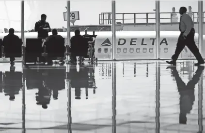  ?? DAVID GOLDMAN/AP ?? A Delta Air Lines jet sits at a gate last October at Hartsfield-Jackson Atlanta Internatio­nal Airport in Atlanta. Despite the recent uproar over a passenger being dragged off a United Express flight, Delta CEO Ed Bastian says overbookin­g is “a valid business process.”