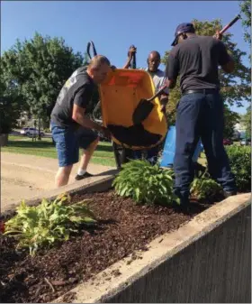  ?? RICHARD PAYERCHIN — THE MORNING JOURNAL ?? From left, Army veterans Denver Limer, Ray Tate and Anthony Lucas deliver mulch to a planter on the wall of Lorain’s Veterans Memorial Park as part of a cleanup effort on Aug. 23. The volunteer effort included planting flowers, pulling weeds and...