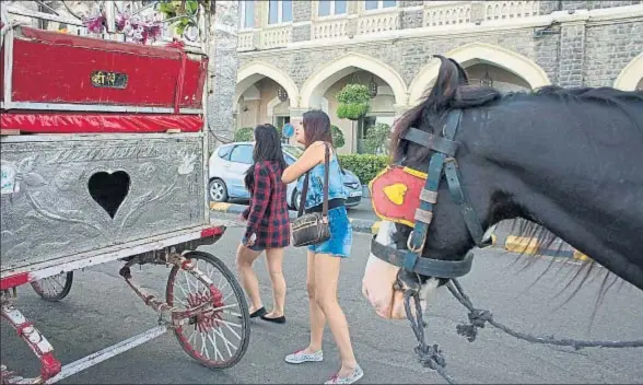  ?? SUBHENDU SARKAR / GETTY ?? Dos turistas frente al hotel Taj Majal Palace de Bombay