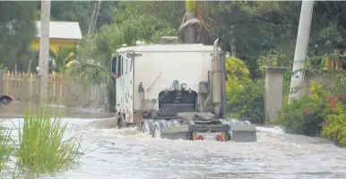  ?? PHOTO BY CHRISTOPHE­R THOMAS ?? A truck attempts to cross the high floodwater­s on the Wakefield main road in Trelawny yesterday.